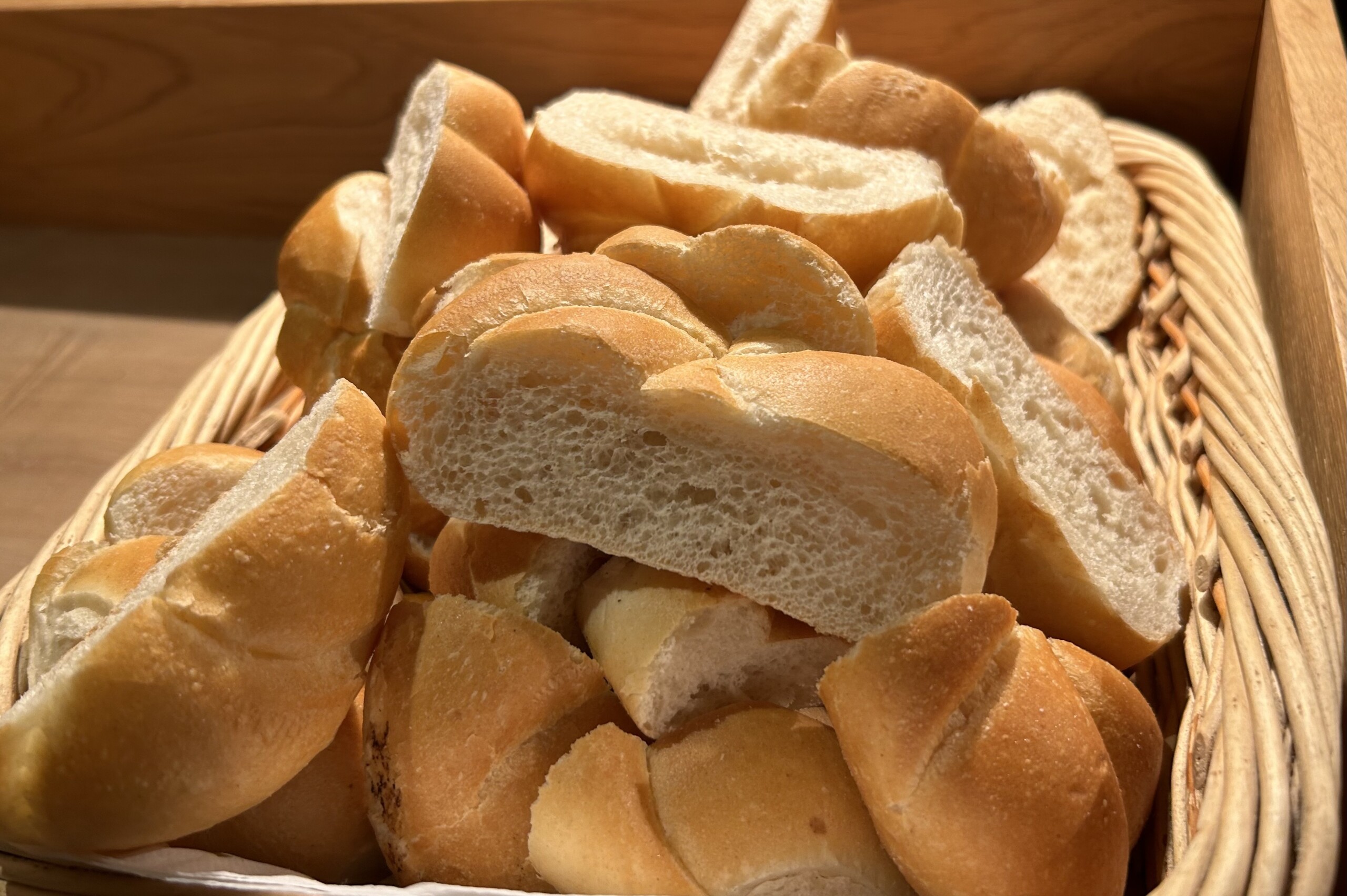 Ein Brotkorb in dem längs geschnittene Semmeln liegen statt Baguette, wahrscheinlich vom Frühstücksbuffet übrig geblieben